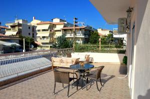 a patio with a table and chairs on a balcony at Casa al mare Anastasia in Nea Kallikrateia
