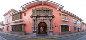 un edificio rosa con un arco en una calle en DM Hoteles Ayacucho, en Ayacucho