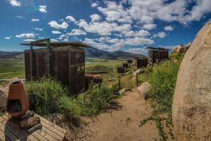 a dirt trail with a row of buildings on a hill at Encuentro Guadalupe in Valle de Guadalupe