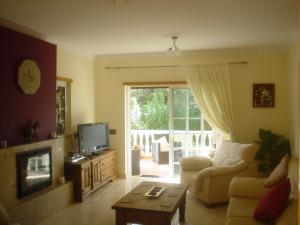 a living room with a couch and a tv at Belar in Tavira