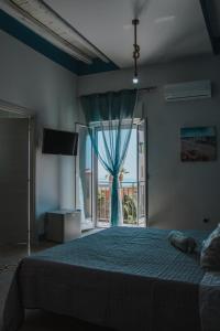 a bedroom with a bed and a large window at Magico Sole in Porto Empedocle