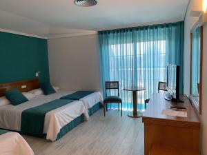 a bedroom with a bed and a desk and a television at Nueva Colina in Tomiño