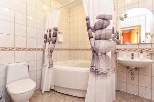 a bathroom with a toilet and a tub and a sink at Hotel Jugend with Self Check-in in Liepāja +82 photos