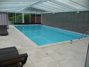 a large swimming pool with an open ceiling at La vieille maison in Cour-Cheverny