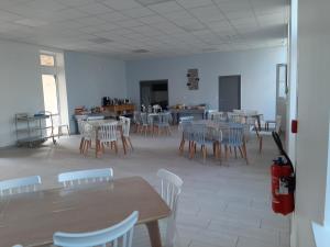 ein Esszimmer mit Tischen und Stühlen und ein Zimmer mit einer Küche in der Unterkunft Le Rayon de Soleil in Châtelaillon-Plage