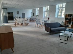 ein Wohnzimmer mit einem Sofa, Tischen und Stühlen in der Unterkunft Le Rayon de Soleil in Châtelaillon-Plage