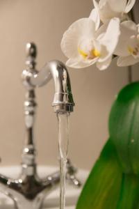 a bathroom sink with water running from a faucet at Anthemio in Loutraki +89 photos