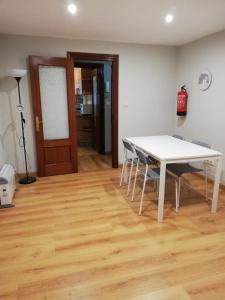 une salle à manger avec une table et des chaises blanches dans l'établissement Alojamiento Quintanilla, à Gijón