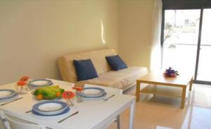 una sala de estar con una mesa y un sofá en Apartamentos Sitges, en Sitges