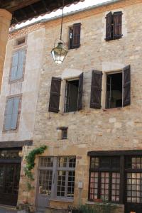 a large brick building with windows and a light fixture at Chambre cozy et Salon de 60 m2 au coeur de la cité in Cordes-sur-Ciel