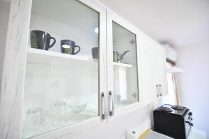 un mobile da cucina con ante in vetro e un lavello di Vulsa Apartmani a Kladovo