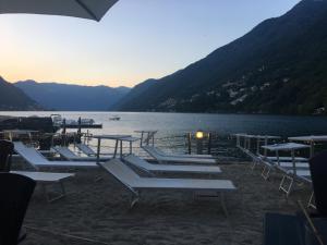 un groupe de tables et de chaises à côté d'un lac dans l'établissement Francesca house, à Erba