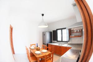a kitchen with a dining room table and a mirror at Casa Los Lajares in La Santa