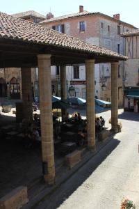 d'une terrasse avec des parasols et des fauteuils. dans l'établissement Chambre cozy et Salon de 60 m2 au coeur de la cité, à Cordes-sur-Ciel