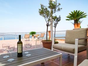 uma garrafa de vinho sentada numa mesa com copos de vinho em Villa Athèna em Taormina