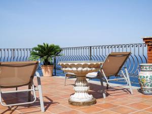 een patio met stoelen, een tafel en een fontein bij Villa Athèna in Taormina
