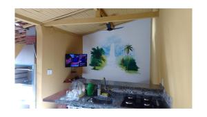 a kitchen counter with a sink and a tv on the wall at POUSO CALIXTRATO in São João Batista do Glória