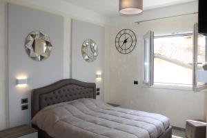 ein Schlafzimmer mit einem Bett und Uhren an der Wand in der Unterkunft Villa Martina Luxury Rooms in Desenzano del Garda