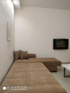 ein Schlafzimmer mit einem Bett und einem Fernseher an der Wand in der Unterkunft LAVIM Apartments 2 in Sykia