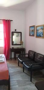 a living room with a couch and a mirror at Mela Studios in Panormos Kalymnos
