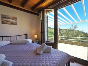 a bedroom with a bed and a large window at Kastanies Country House in Skopelos Town