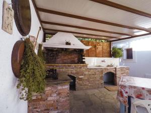 an outdoor kitchen with a stone fireplace in a house at Kastanies Country House in Skopelos Town