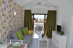 a living room with a couch and a television at Casa Verol, F2 in Caleta De Fuste