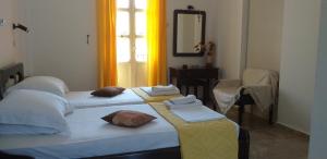 a bedroom with two beds and a mirror and a window at Mela Studios in Panormos Kalymnos