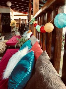 a row of pillows on a bench with lights at Woodstock Hostel in Sámara