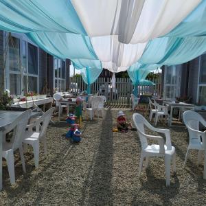 ブラゴヴェシェンスカヤにあるБунгало клуб "Moredomik"のパティオ(白いテーブルと椅子付)、子供用のテントを利用できます。