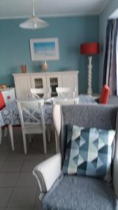 sala de estar con sofá, mesa y sillas en Sans Souci, en De Panne