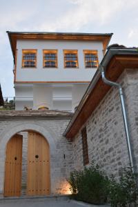 a house with wooden doors and a brick wall at Argyropolis Boutique Hotel in Gjirokastër