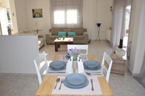 a living room with a table with blue dishes on it at Casa al mare Anastasia in Nea Kallikrateia