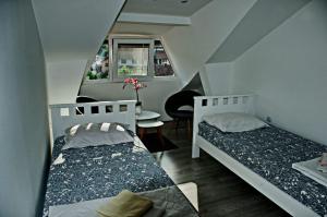 a bedroom with two beds and a table with a chair at Guest House Stankovic in Soko Banja