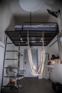a room with a bed and a ladder at Wake Up Wellness Hostel in Brno