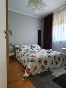 a bedroom with a bed with a comforter on it at Ninho Jardim do Morro in Vila Nova de Gaia