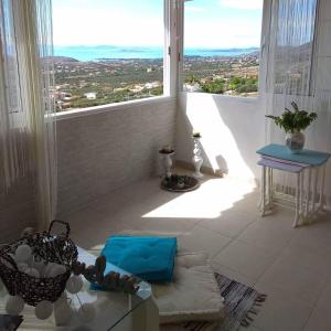 a room with a large window with a view of a city at Outstanding Panoramic View, 10΄ beach, 20΄ airport in Ólimbos