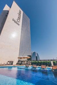 a hotel with a swimming pool in front of a building at Cullinan Hplus Premium Flat Vip in Brasilia