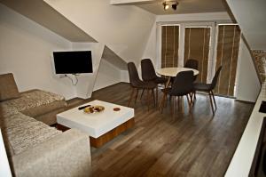 a living room with a couch and a table and chairs at Guest House Stankovic in Soko Banja