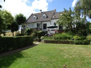 a white house with a lawn in front of it at Roer, huisje aan de Maas in Maren-Kessel +75 photos