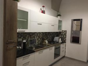 a kitchen with a sink and a stove at Guest House Nonna Lena in Carovigno