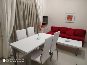a living room with a white table and red couch at LAVIM Apartments in Sikia