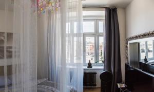 a room with a window, a sink, and a bathtub at Wake Up Wellness Hostel in Brno