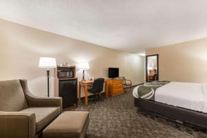 a hotel room with a bed and a desk and chair at Quality Inn & Suites in Portage