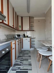 a kitchen with white cabinets and a black and white tile floor at Ninho Jardim do Morro in Vila Nova de Gaia