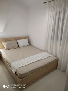 a bedroom with a large bed with a window at LAVIM Apartments in Sikia