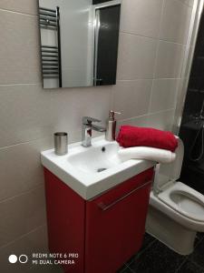 a bathroom with a red sink and a toilet at LAVIM Apartments in Sikia +32 photos