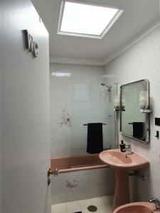 a bathroom with a sink and a shower with a mirror at Ninho Jardim do Morro in Vila Nova de Gaia