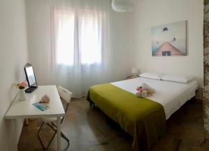 a bedroom with a bed and a table and a window at Casa da Ilaria in Sottomarina