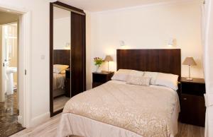 a bedroom with a large bed and a mirror at Westport View Apartments in Westport